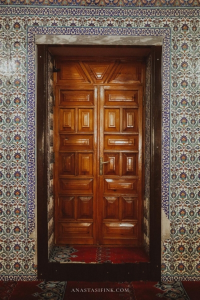 Beautifully crafted wooden door at Fırfırlı Cami Mosque, surrounded by intricate tile work.