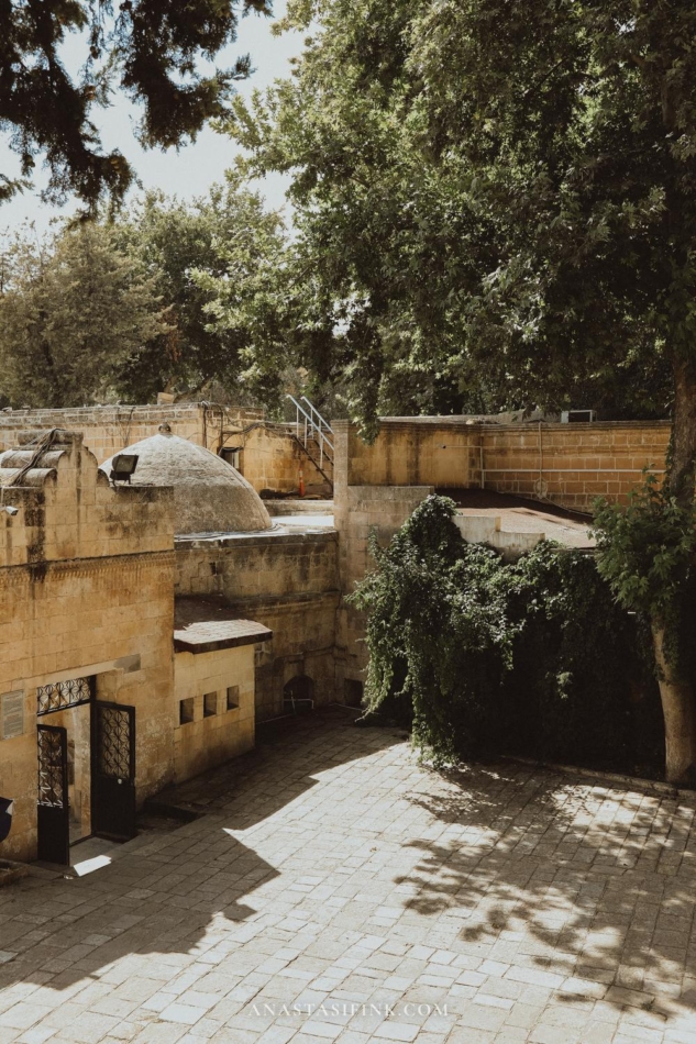 Pathway through lush greenery and historic structures at Golbasi Park.