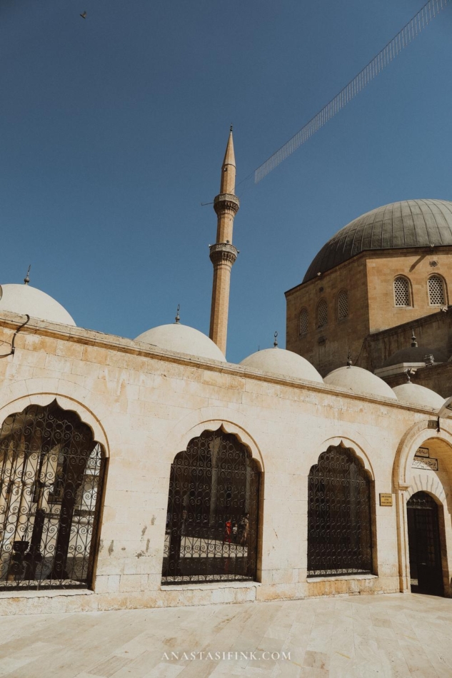 Serene courtyard of Mevlid-i Halilulrahman Magarası featuring traditional architecture.