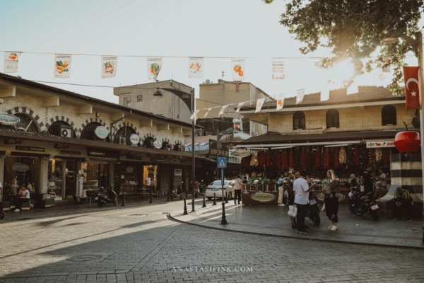 The exterior view of the Copper Bazaar, showing people walking by and the market's entrance.