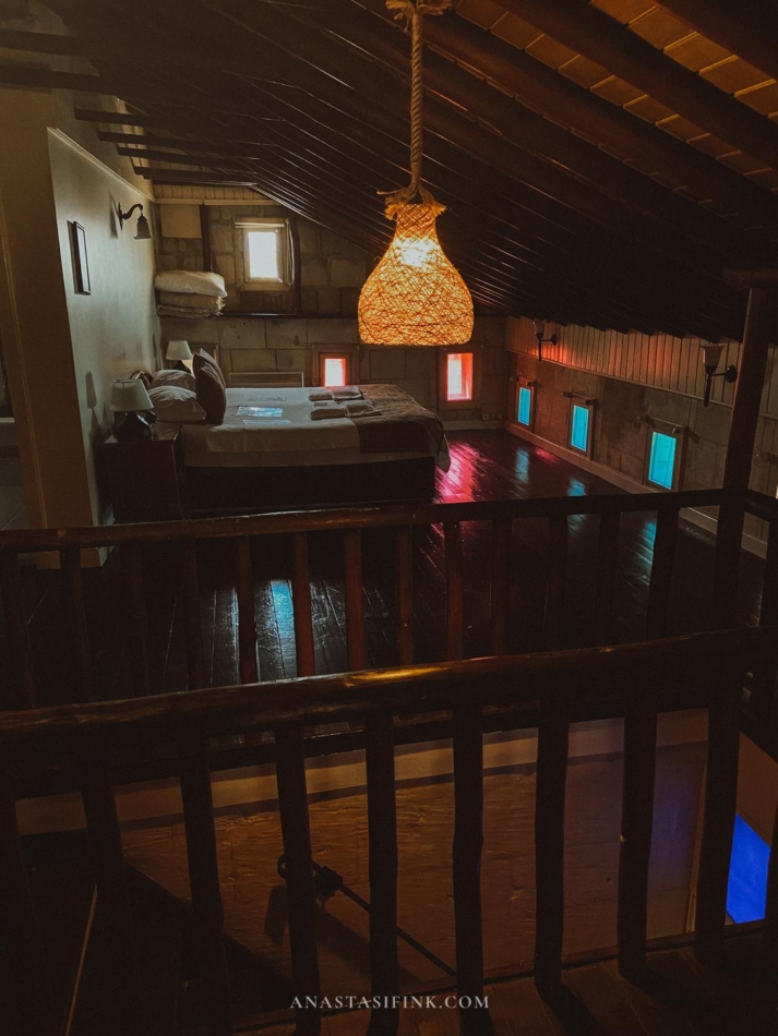 The room under the roof with wooden beams and cozy lighting.