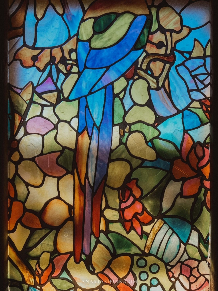 A beautiful stained glass window depicting a bird and floral design in Anadolu Evleri Hotel