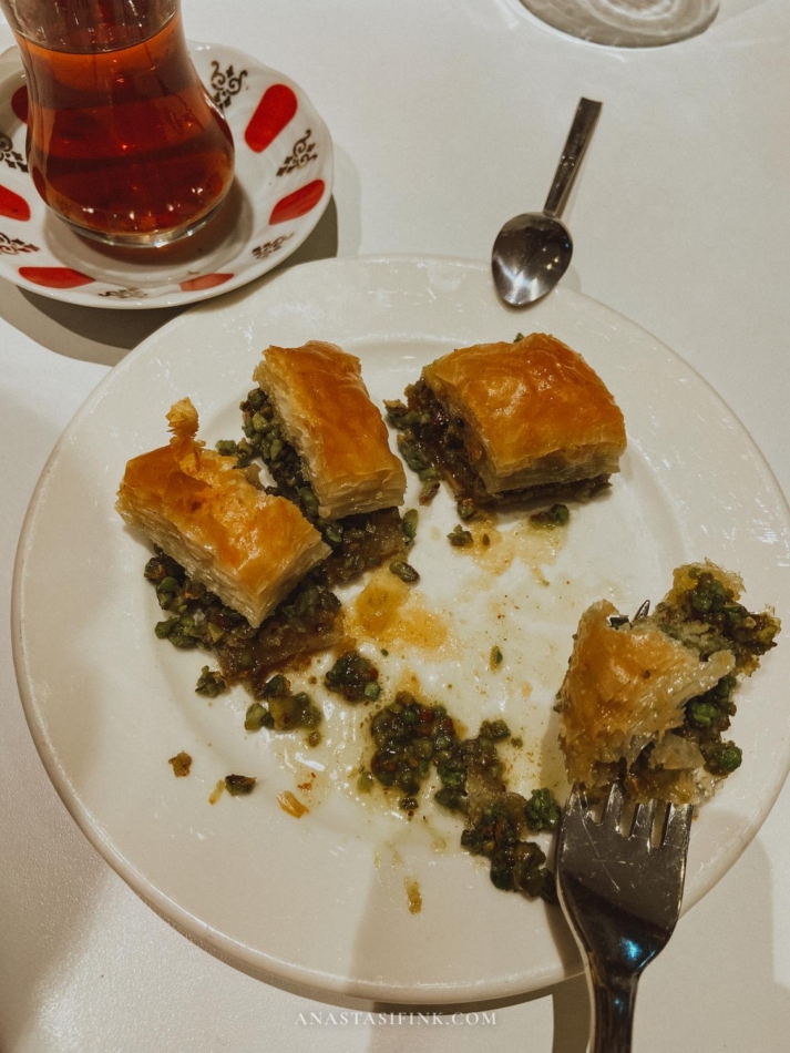 A plate with pieces of baklava, served with a fork.