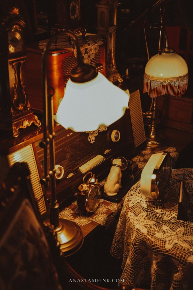  A vintage desk lamp and other antique items on a desk in Gramofhan Antika store.