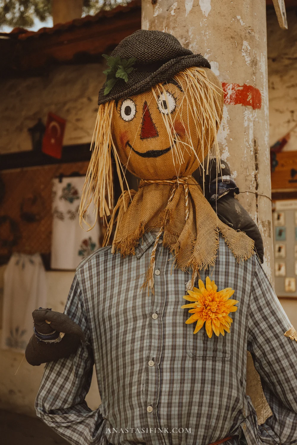 Классическое пугало в клетчатой рубашке и шляпе с жёлтым цветком