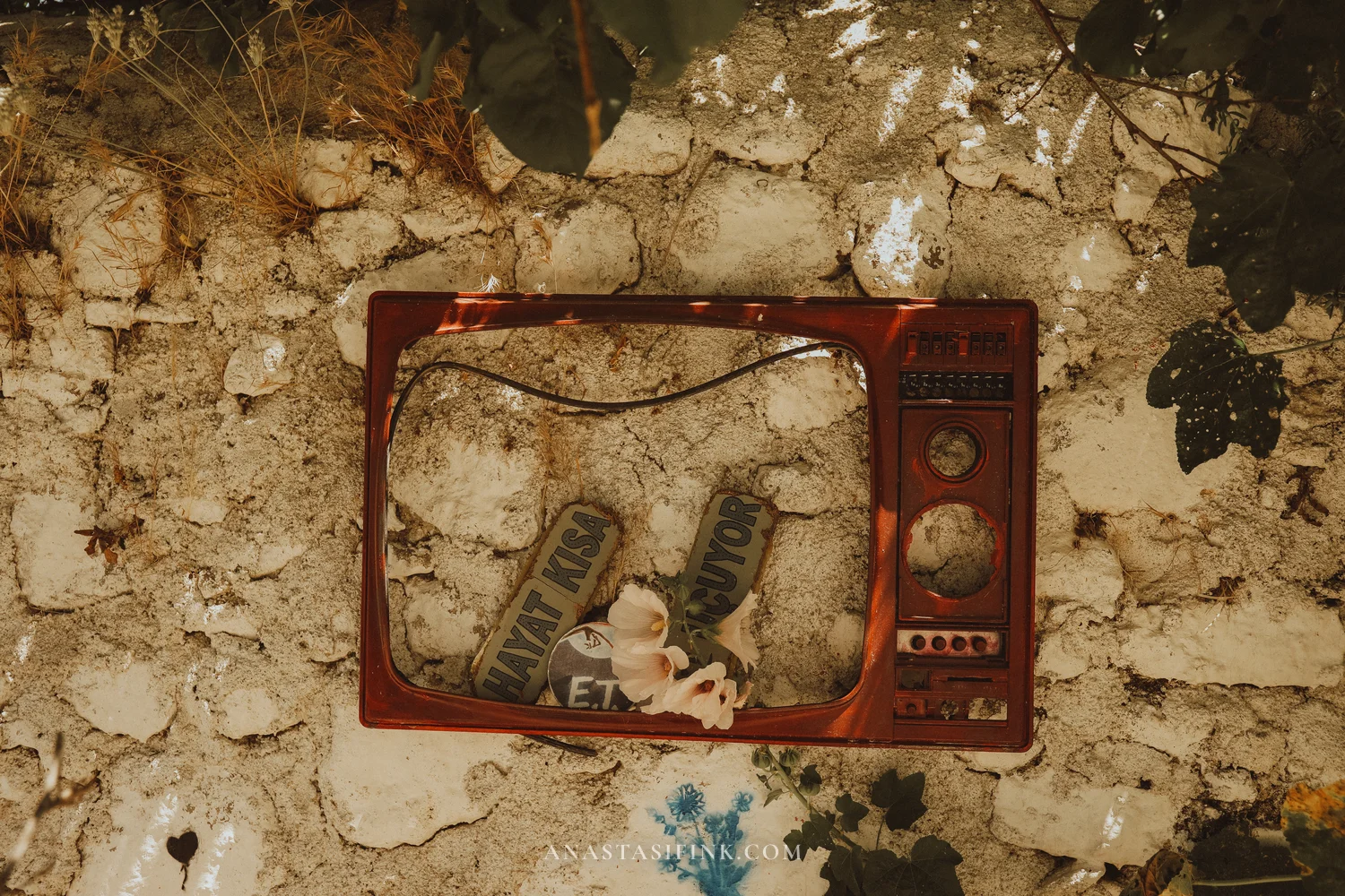 Old red TV frame in a stone wall with