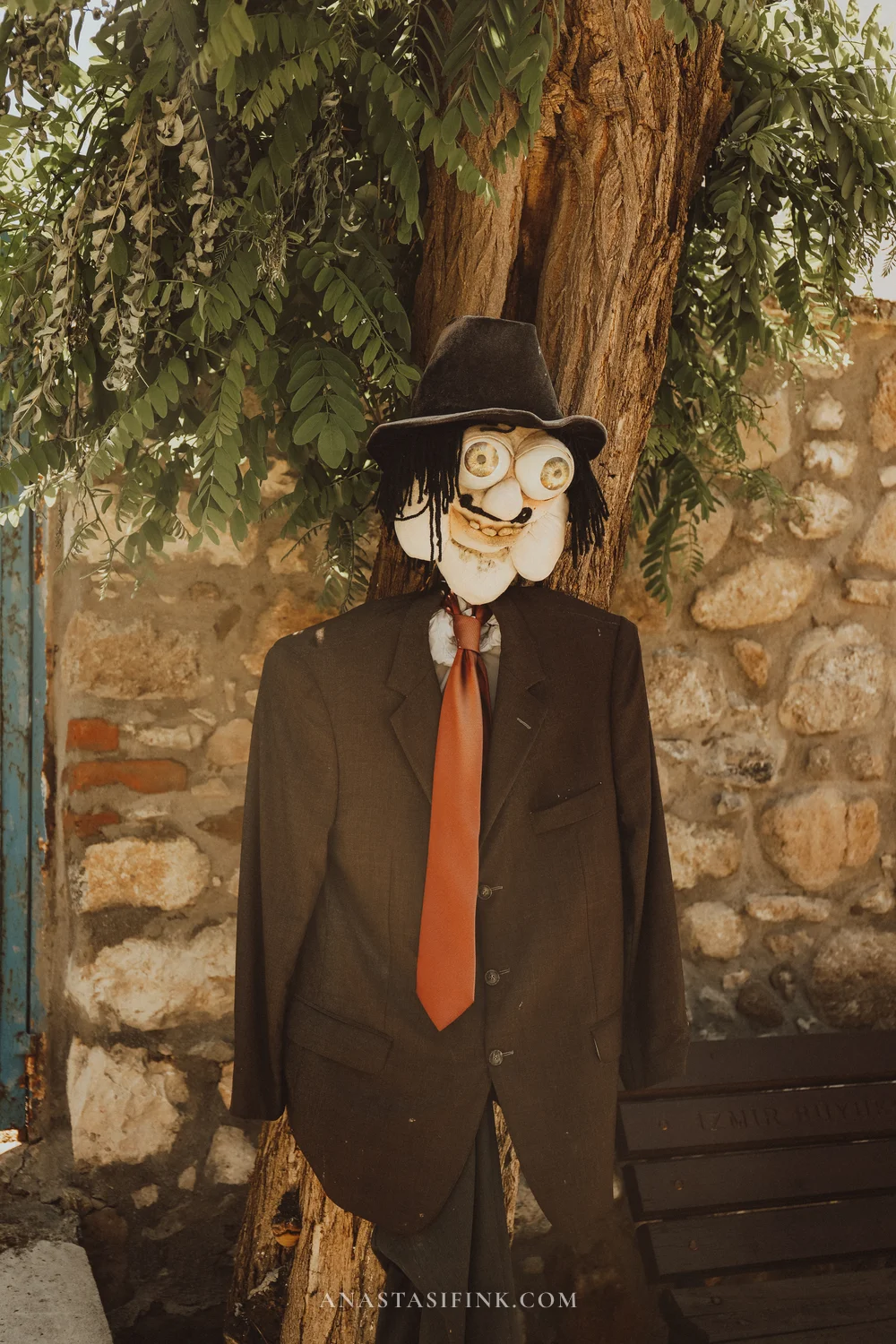 Scarecrow in a black suit with a red tie and hat