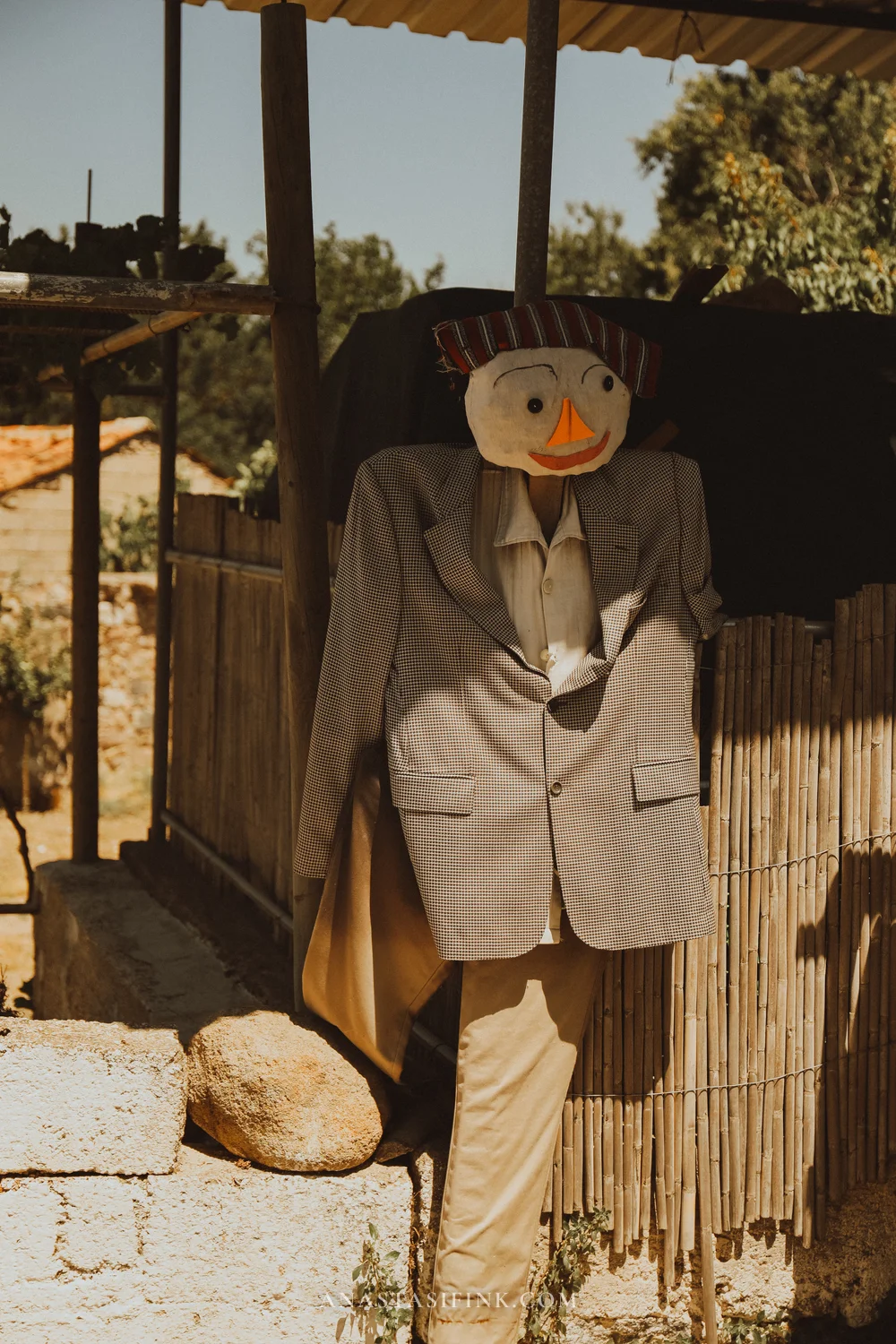 Gentleman scarecrow in a suit and striped hat