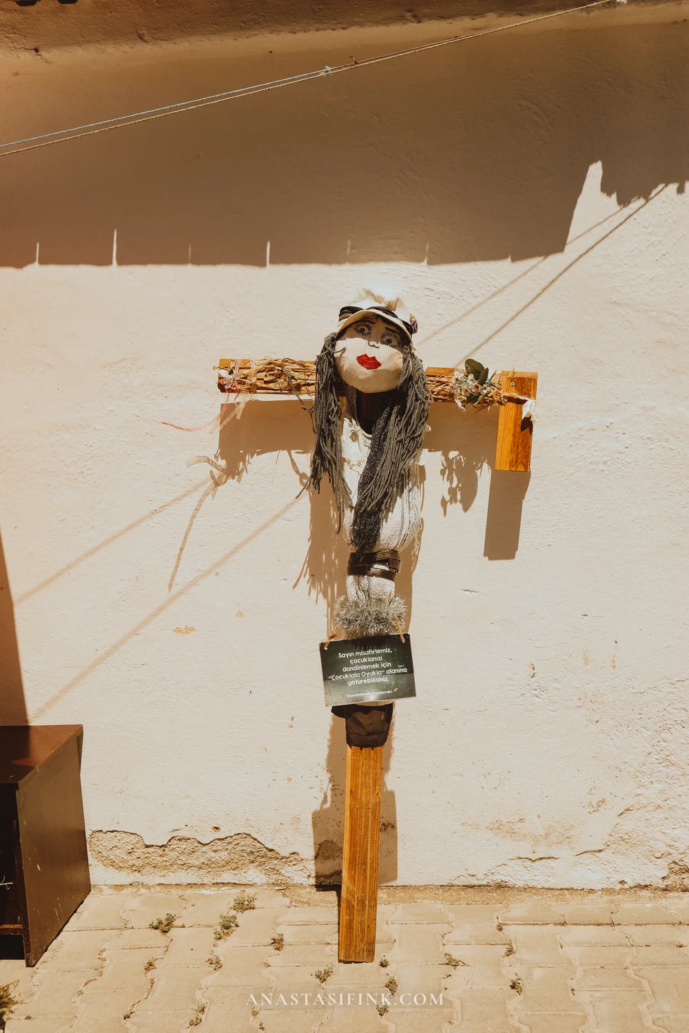 Female scarecrow with red lips on a wooden frame