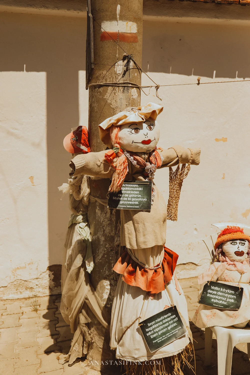 Scarecrows on a pole with signs in Turkish