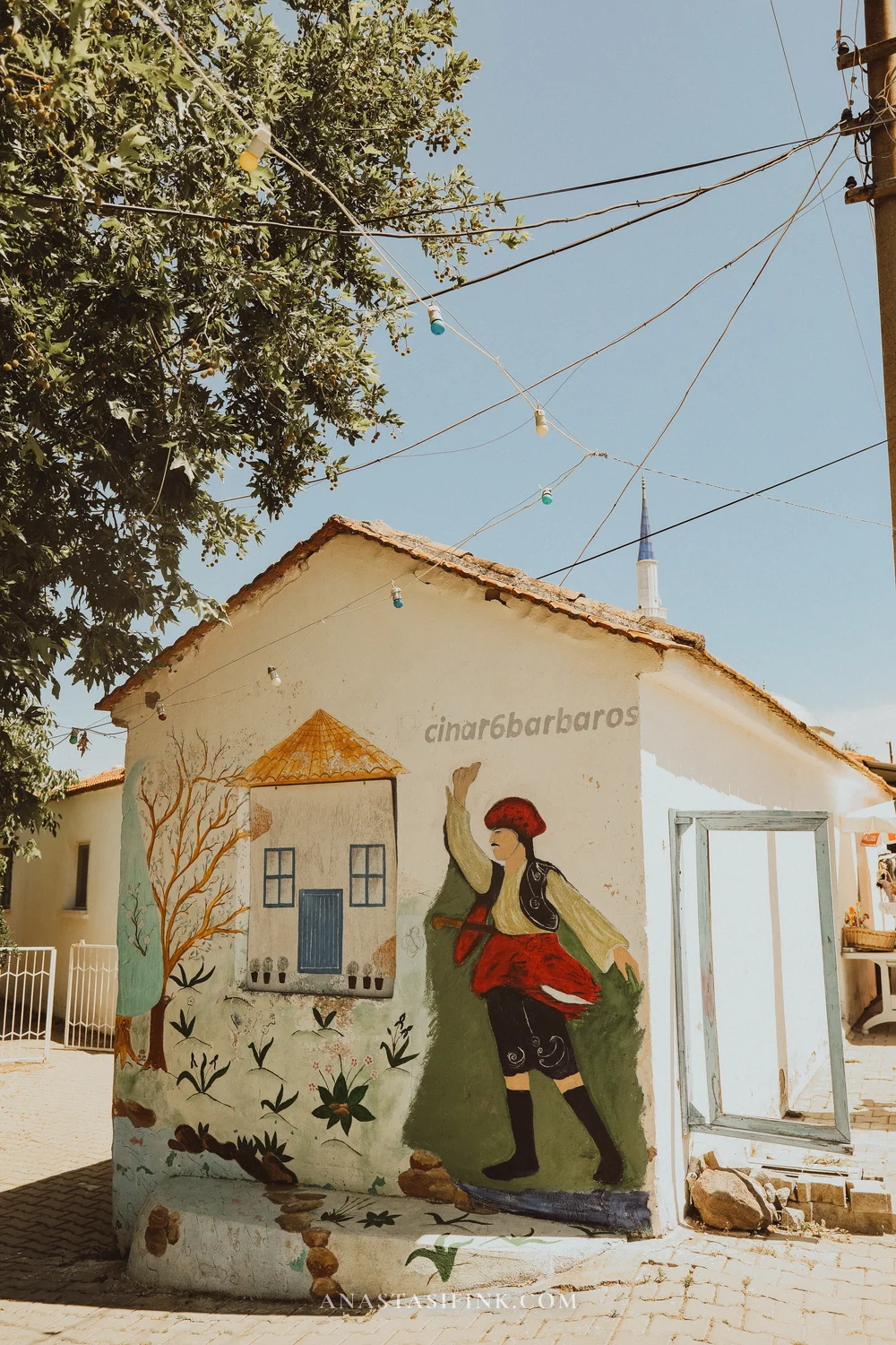 Mural of a figure in traditional costume on a house wall,