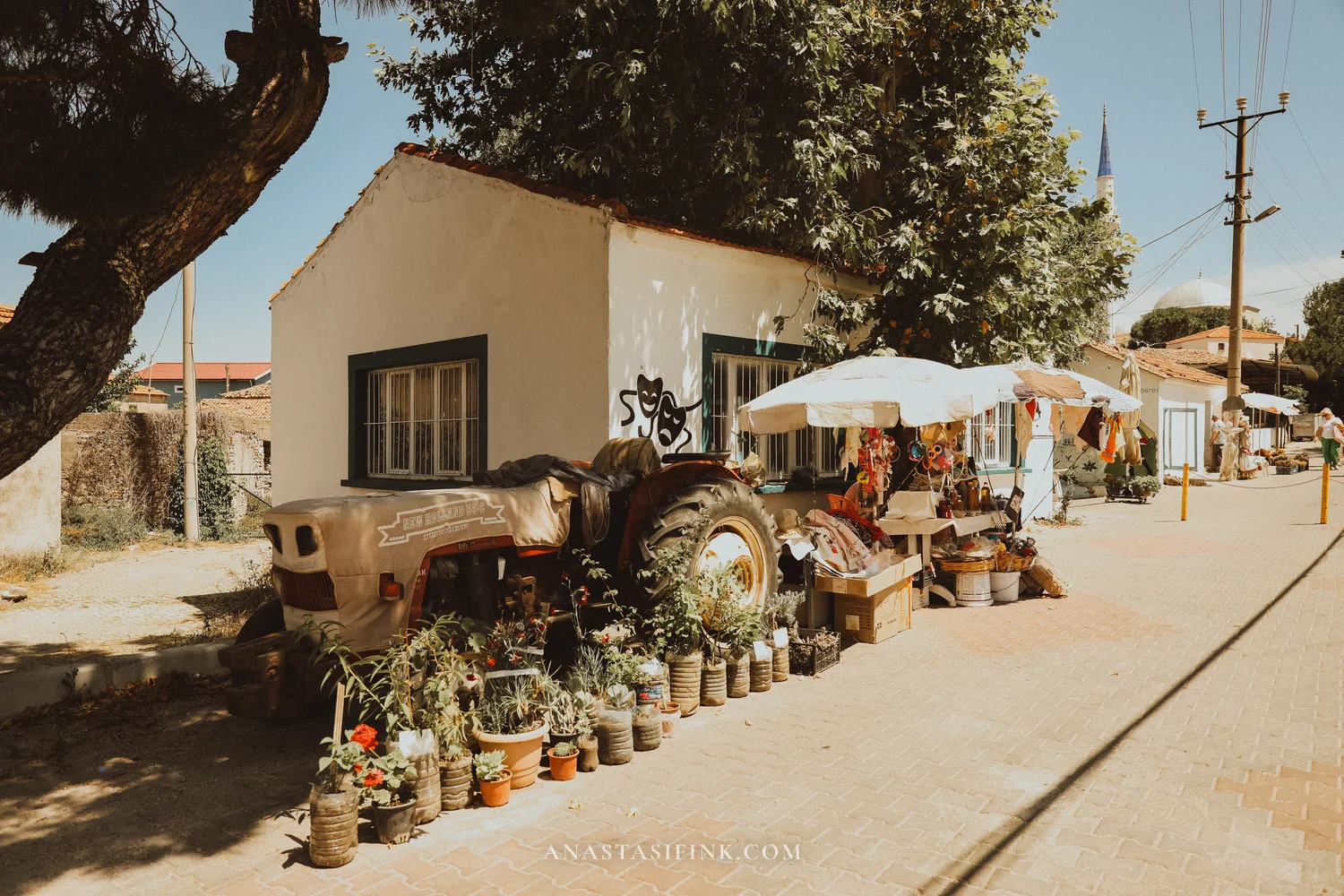 Barbaros street — old tractor covered in flowers, whitewashed houses, minaret in the background