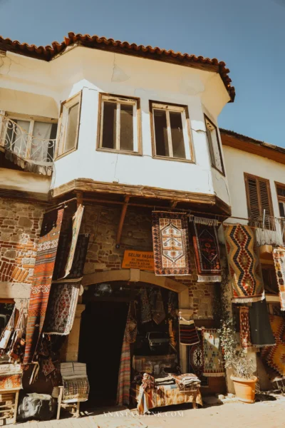 Entrance to the Selim carpet shop — an old house with a bay window, carpets from floor to roof
