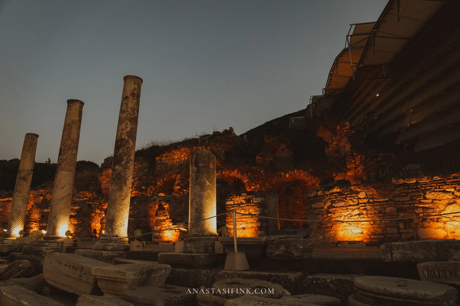 Colonnade against a deep blue evening sky, amber floodlights from below