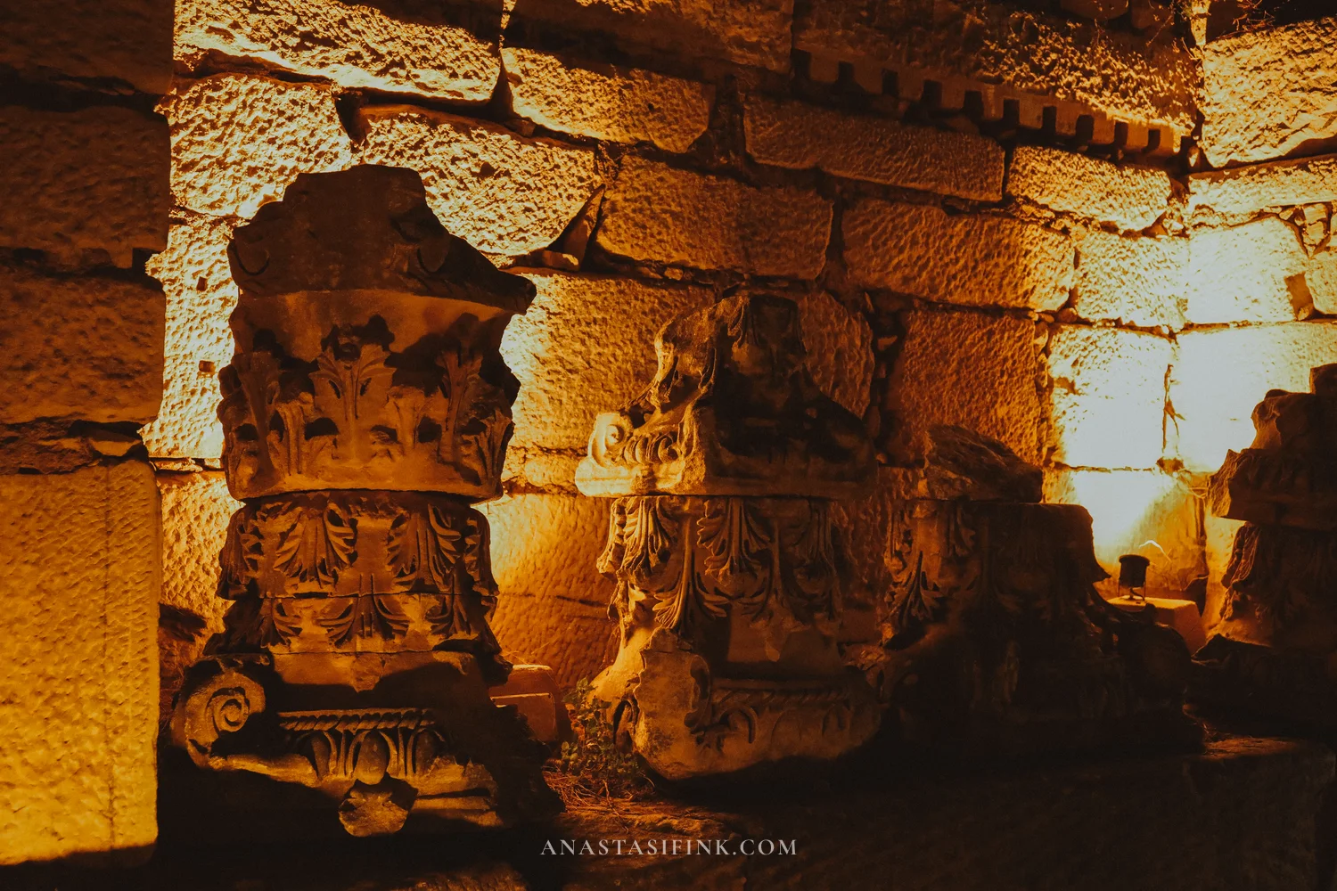 Corinthian capitals in close-up in dark amber light