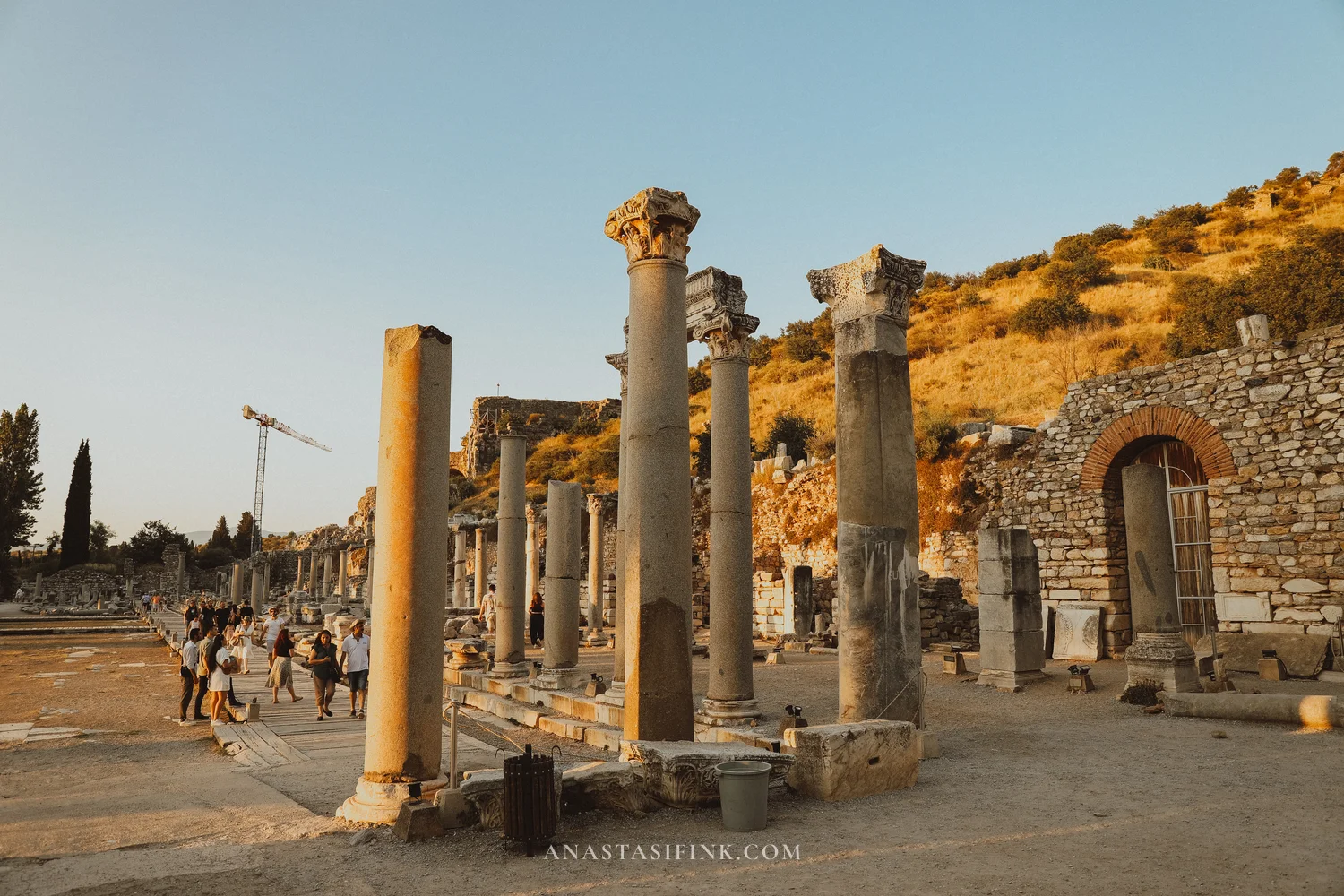 Curetes Street with columns, tourists walking along the paved road