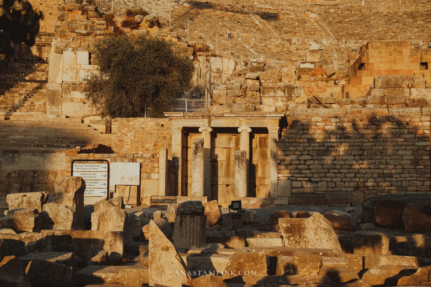 View of the Odeon and gates with a sign pointing to the Library of Celsus