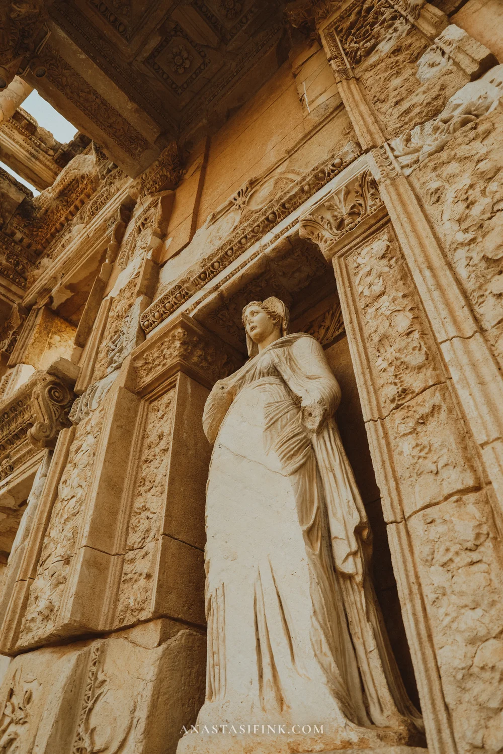 Statue of Sophia in a niche of the Library of Celsus, intricate ornament surrounding it