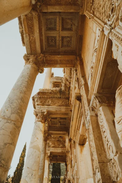 Looking up at the coffered ceiling and carved friezes of the Library of Celsus