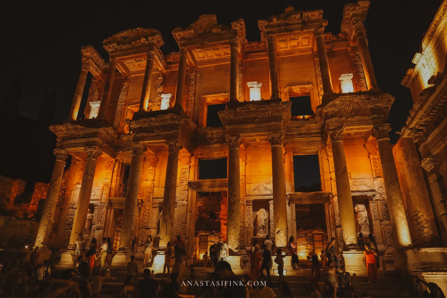 Amber facade of the Library of Celsus at night, wide shot