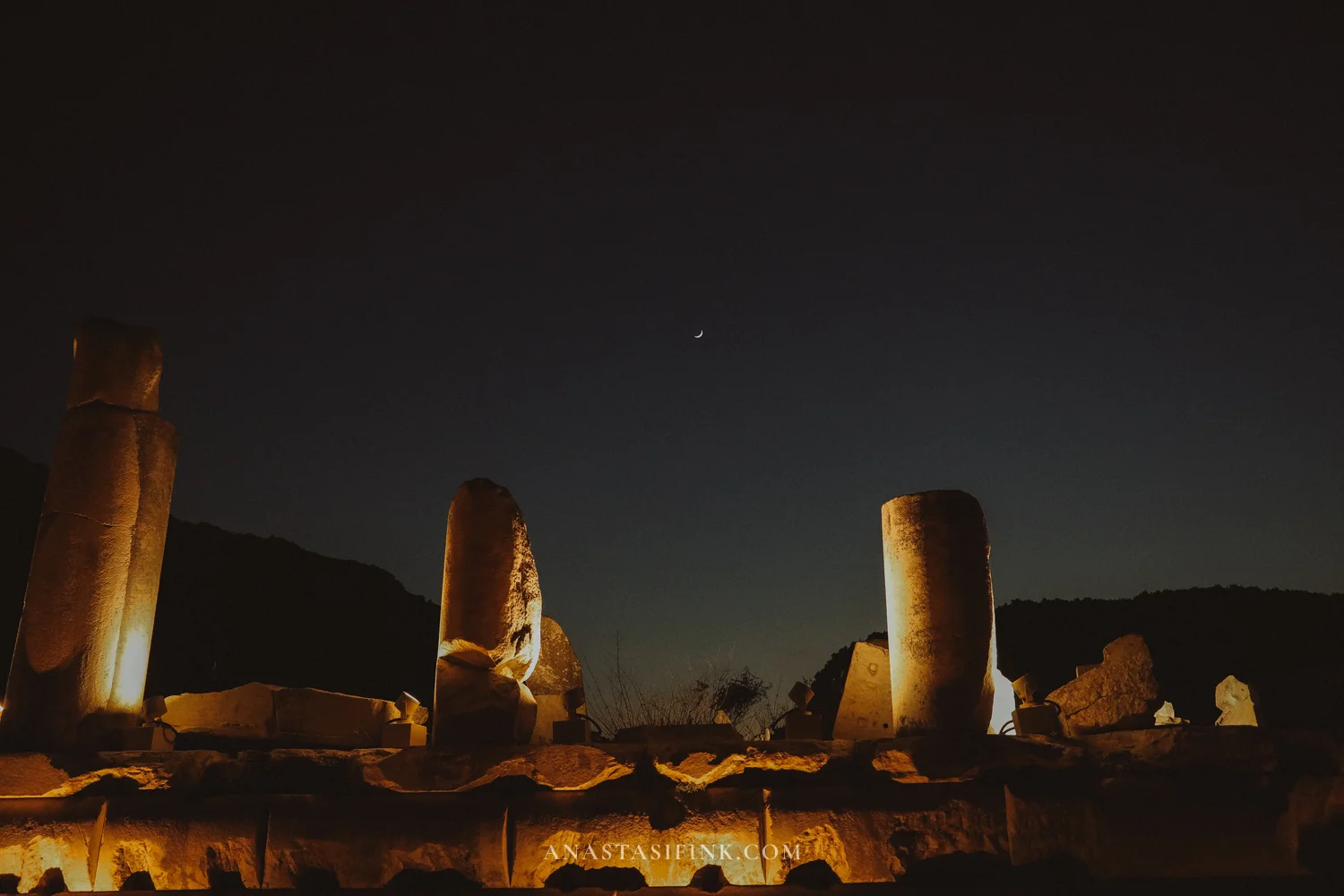 Ruins with a crescent moon and columns in a deep blue night sky