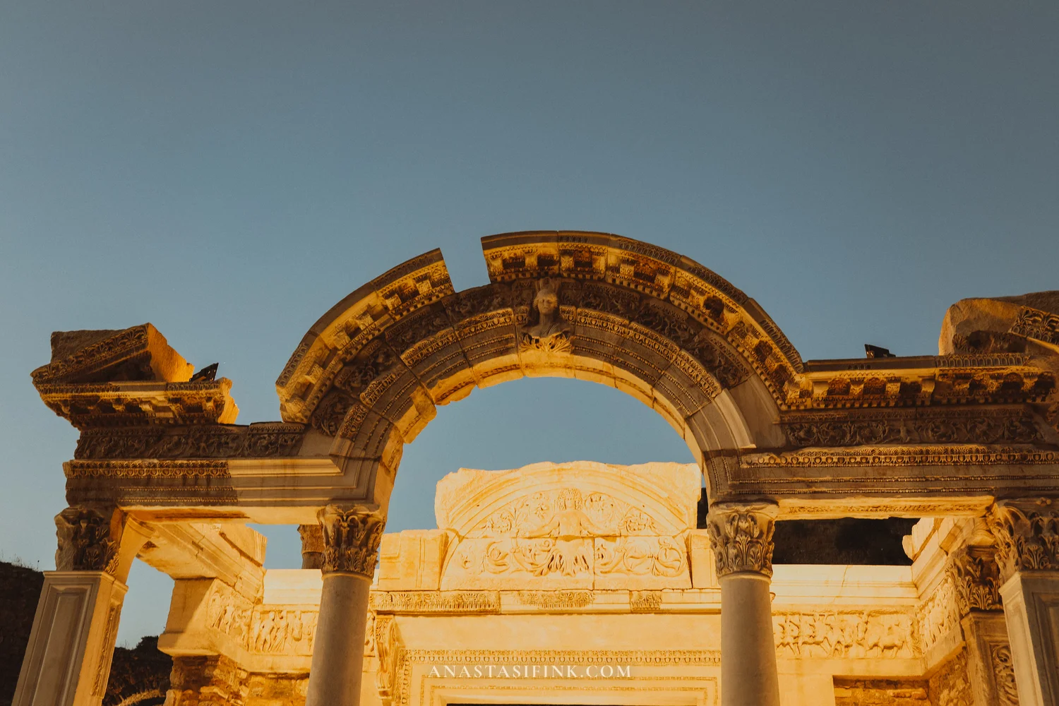 Arch of the Temple of Hadrian in close-up, warm evening light