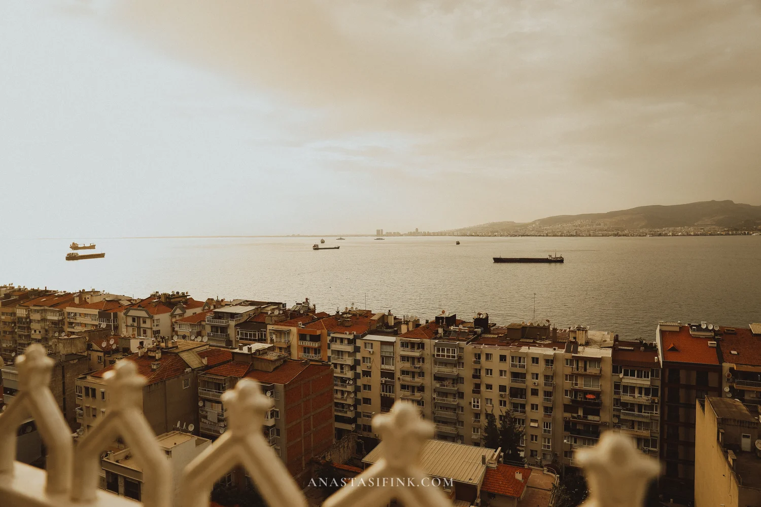 Bay view from rooftops — ships, tile roofs, mountains