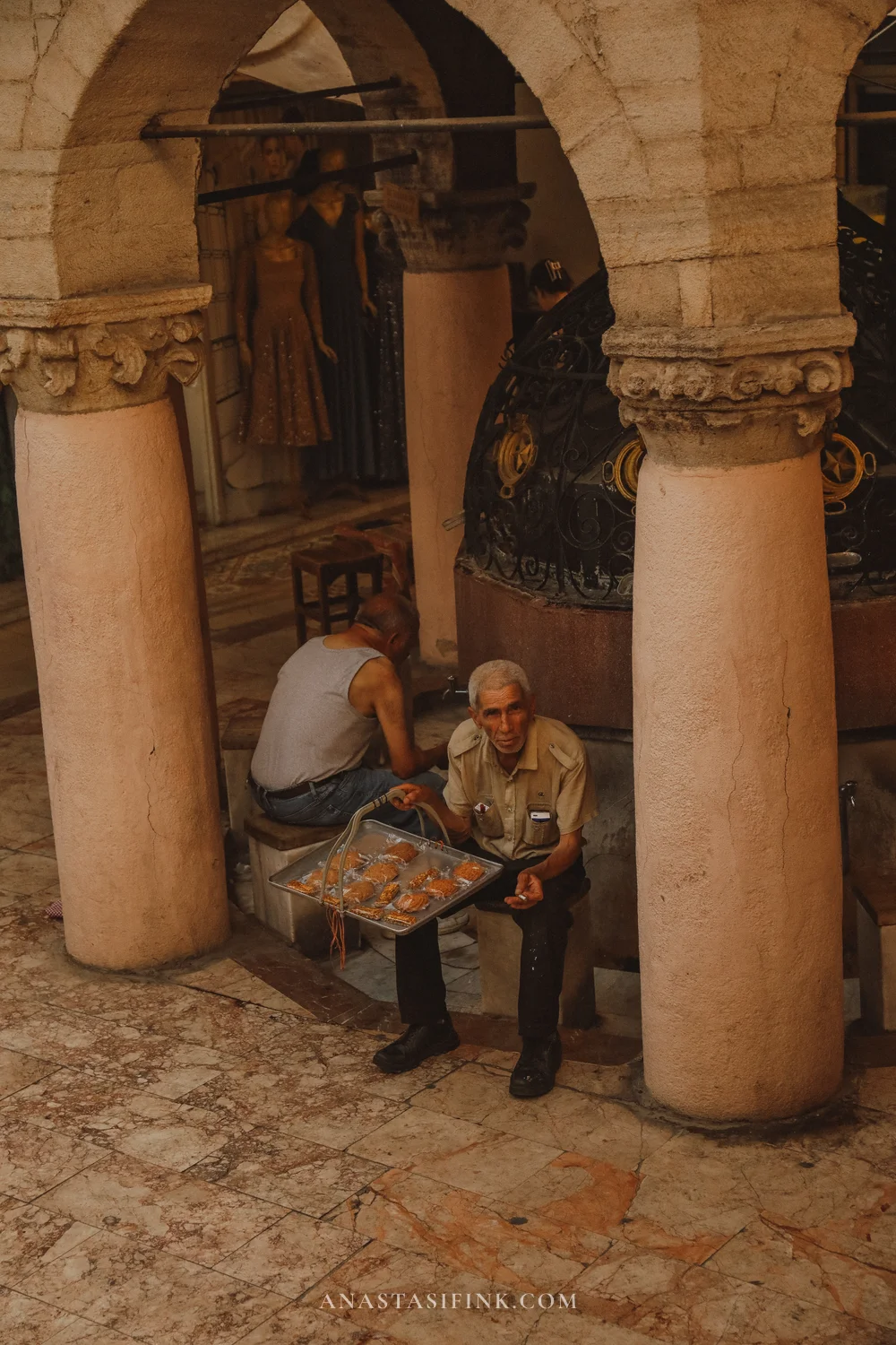 Vendor under the passage arches — they sell here now just as they did two hundred years ago