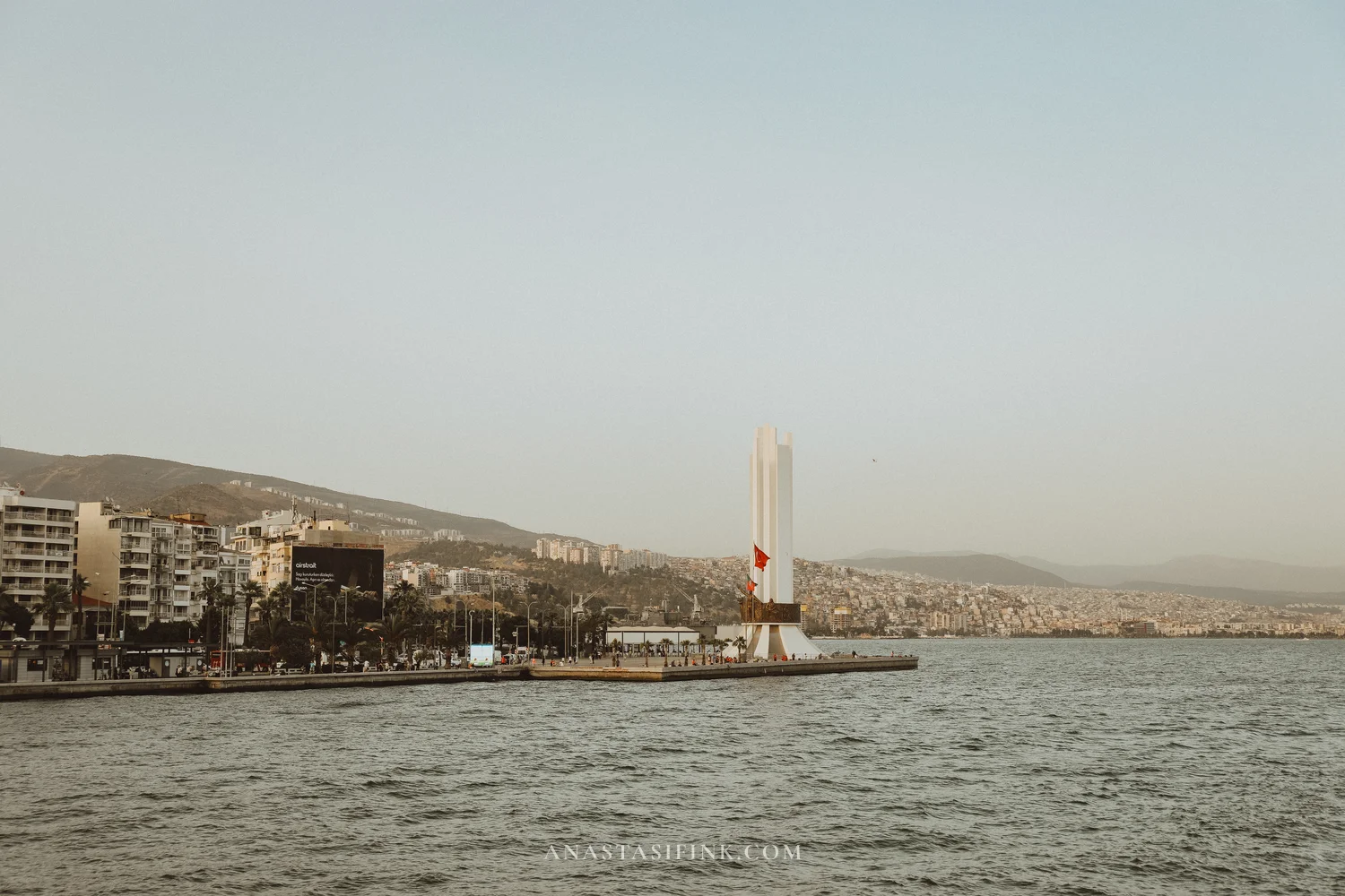 Izmir waterfront with white monument — view from ferry