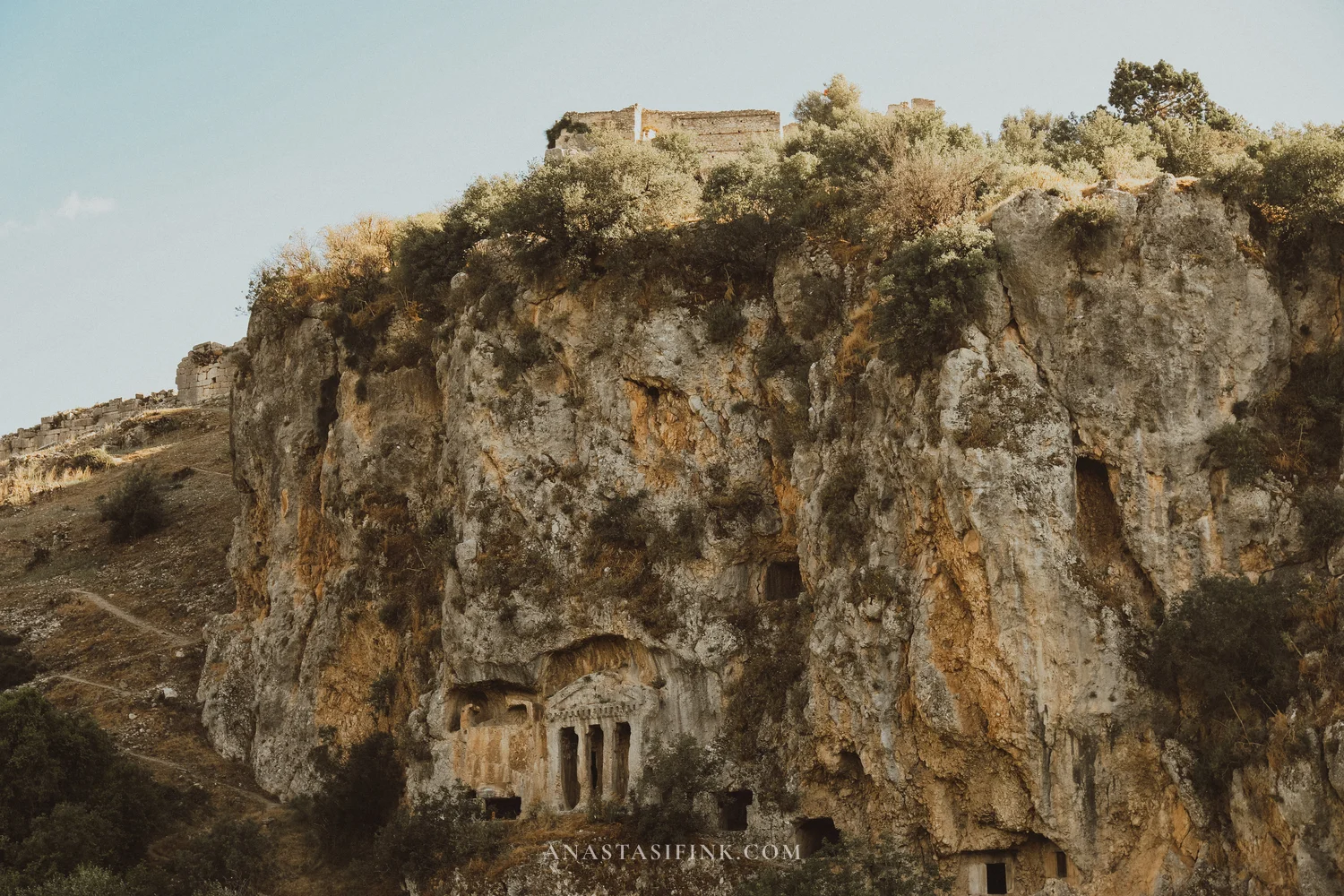 Distant view — cliff tombs and fortress on top