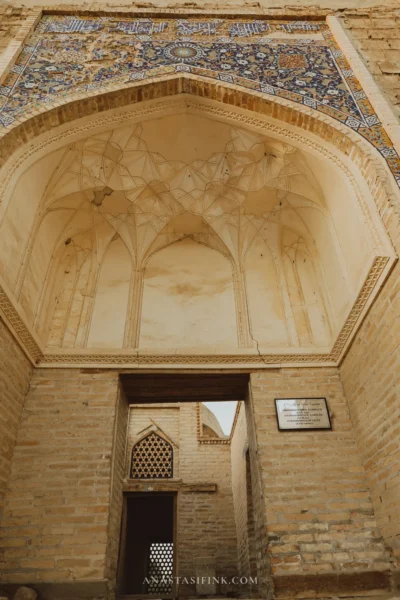 Main portal with mosaic tile band over the arch and Arabic calligraphy