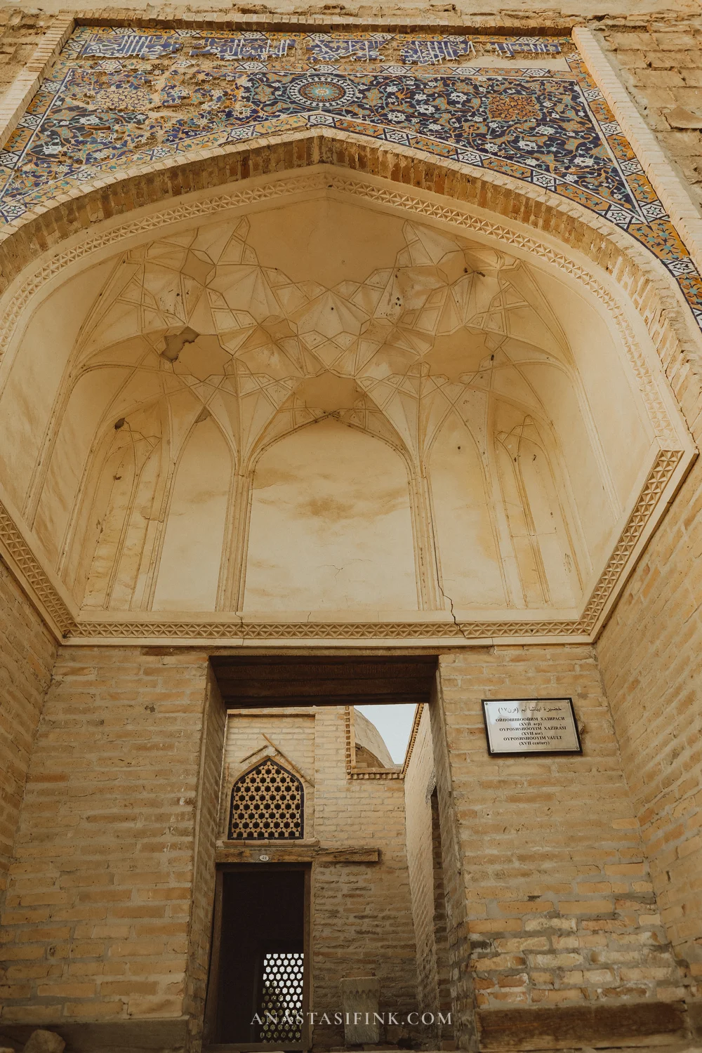 Main portal with mosaic tile band over the arch and Arabic calligraphy