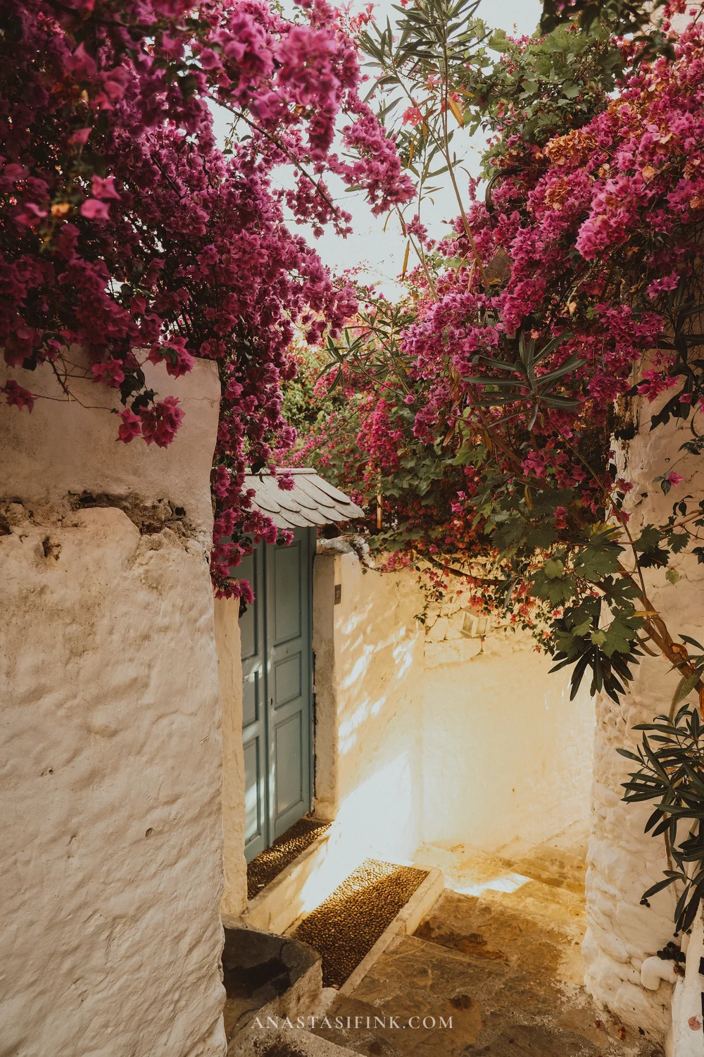 Голубая дверь в переулке со ступенями и цветущей бугенвиллеей в старом городе Мармариса, Турция