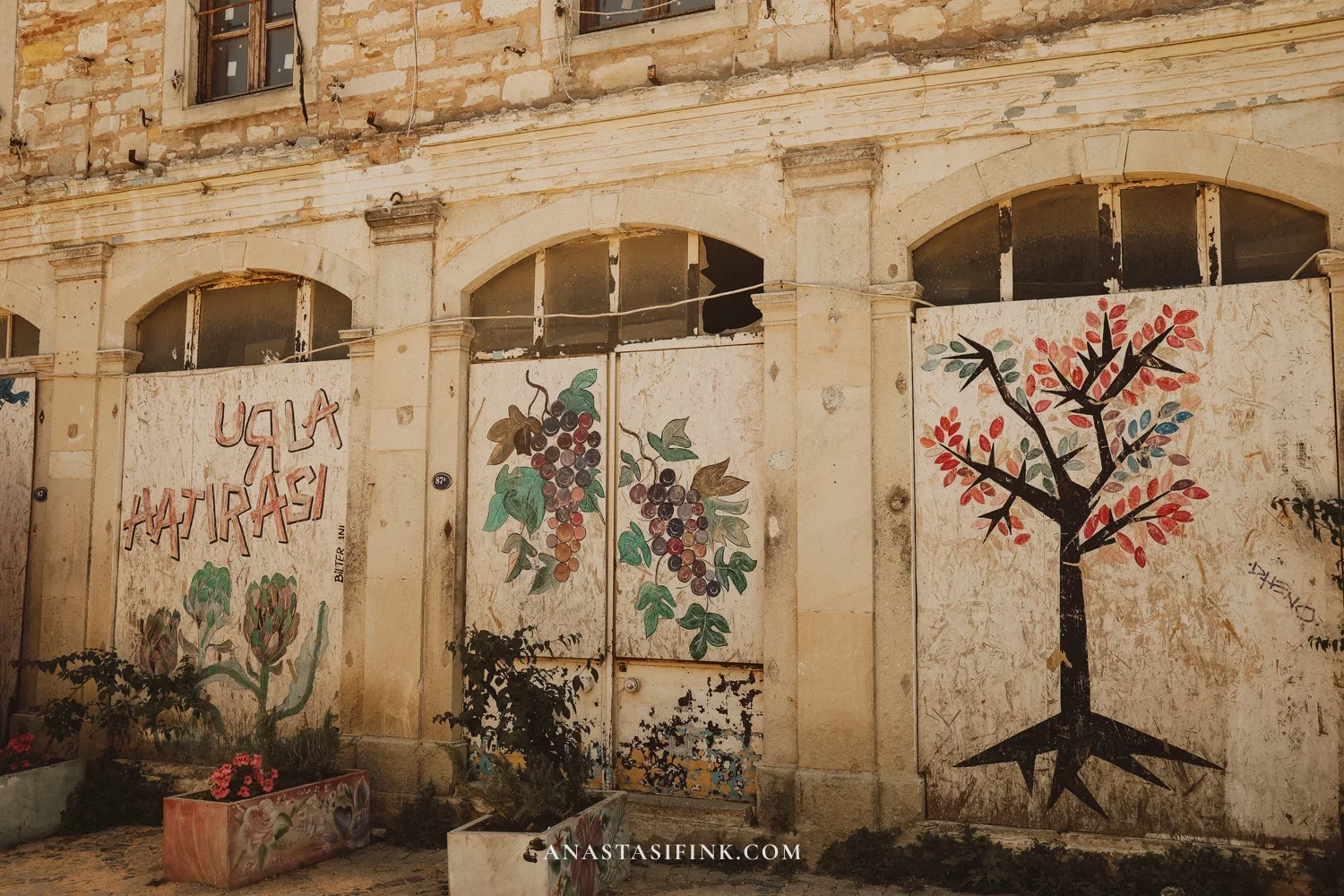 Urla Hatırası mural on an old building wall — artichokes, grapes, and a tree