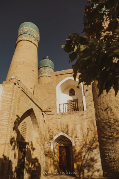 Chor Minor: four minarets with green domes and an arched entrance to the lower tier