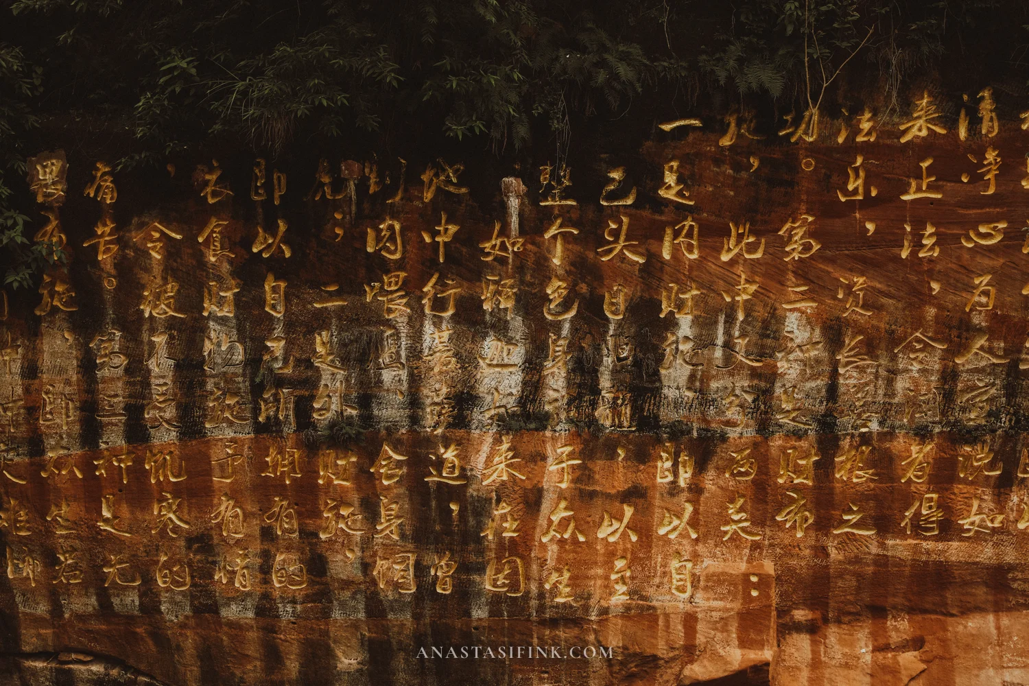 Carved gold characters on the cliff at the Giant Buddha