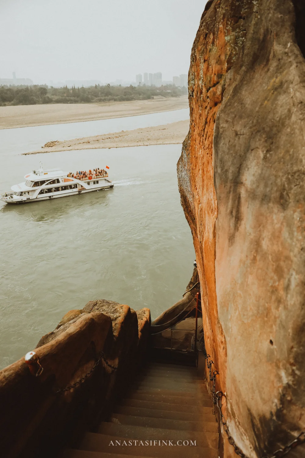 Descent down steps above the river with a boat below