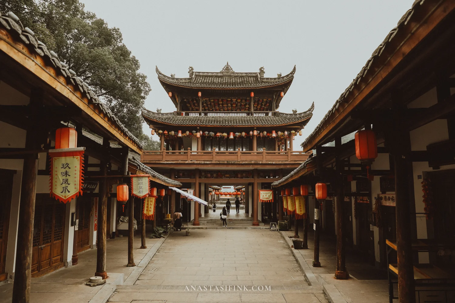 Old street with red lanterns and a gate tower at the park exit