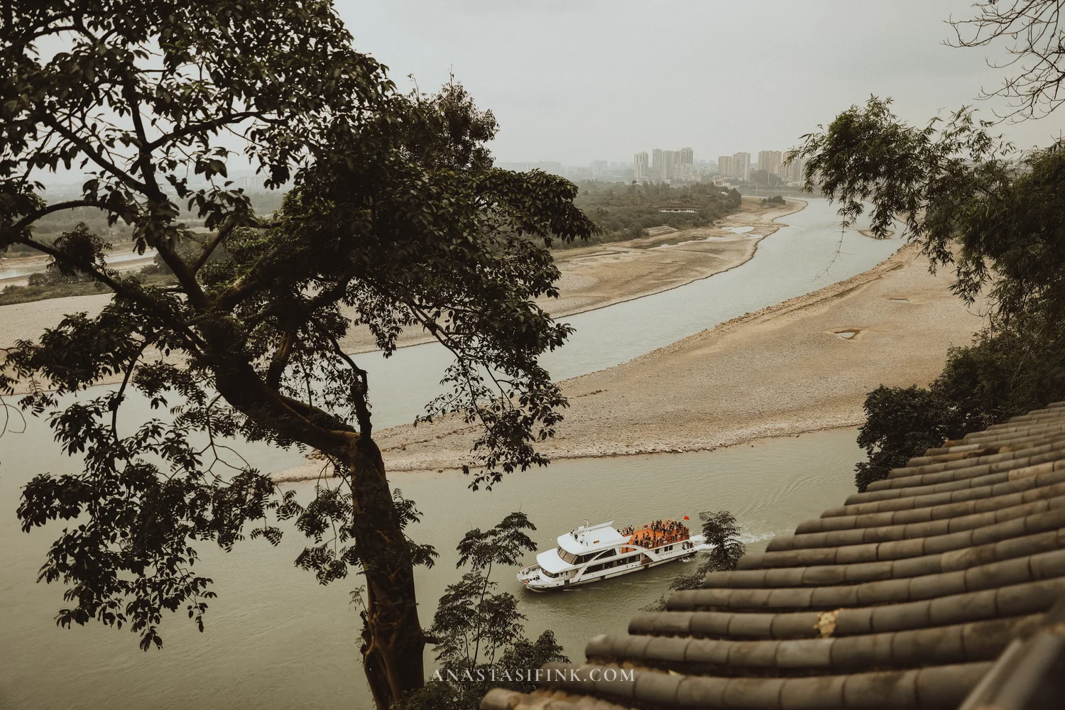 View of the river with a tour boat from the Giant Buddha