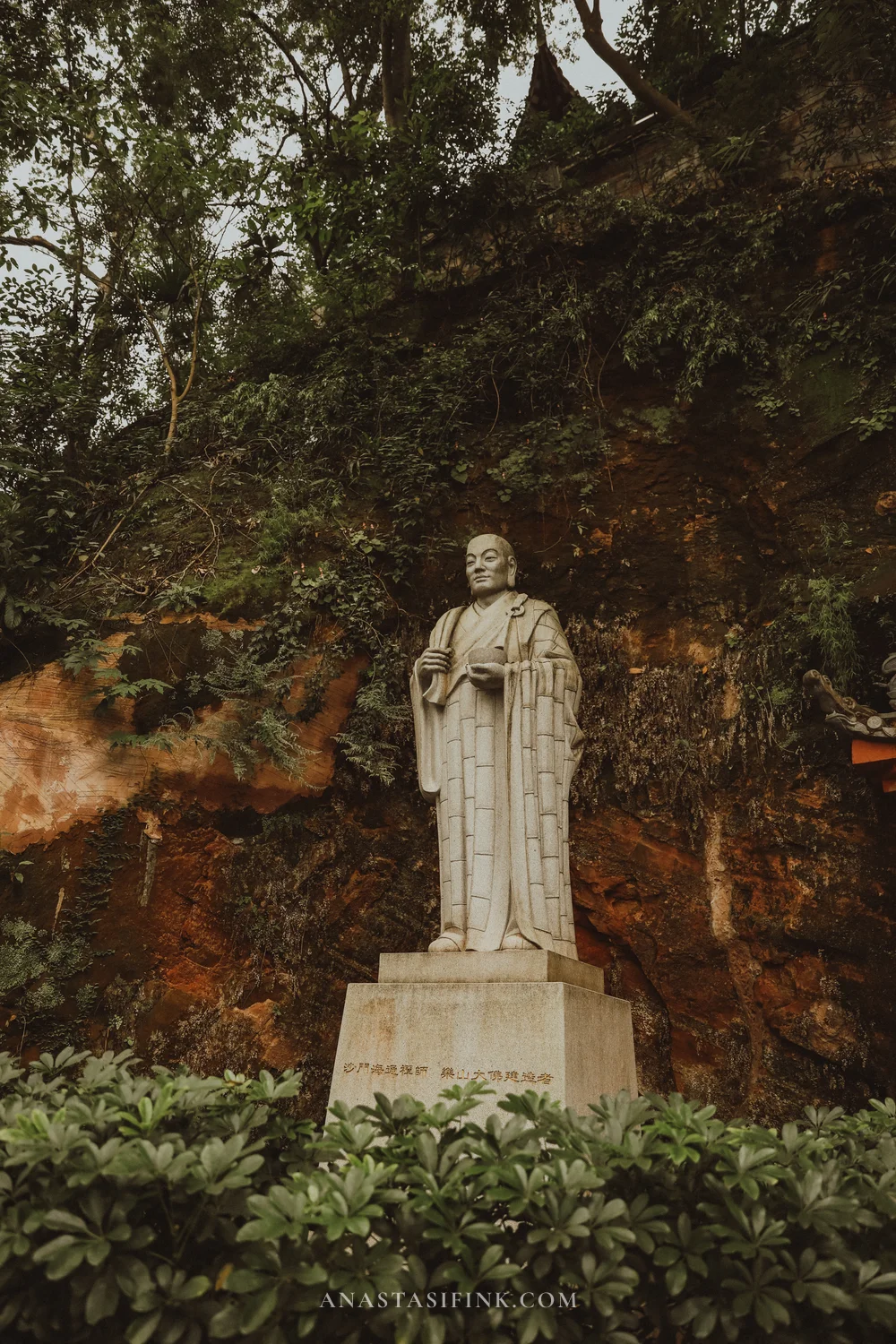 White statue of the monk Haitong by the cliff
