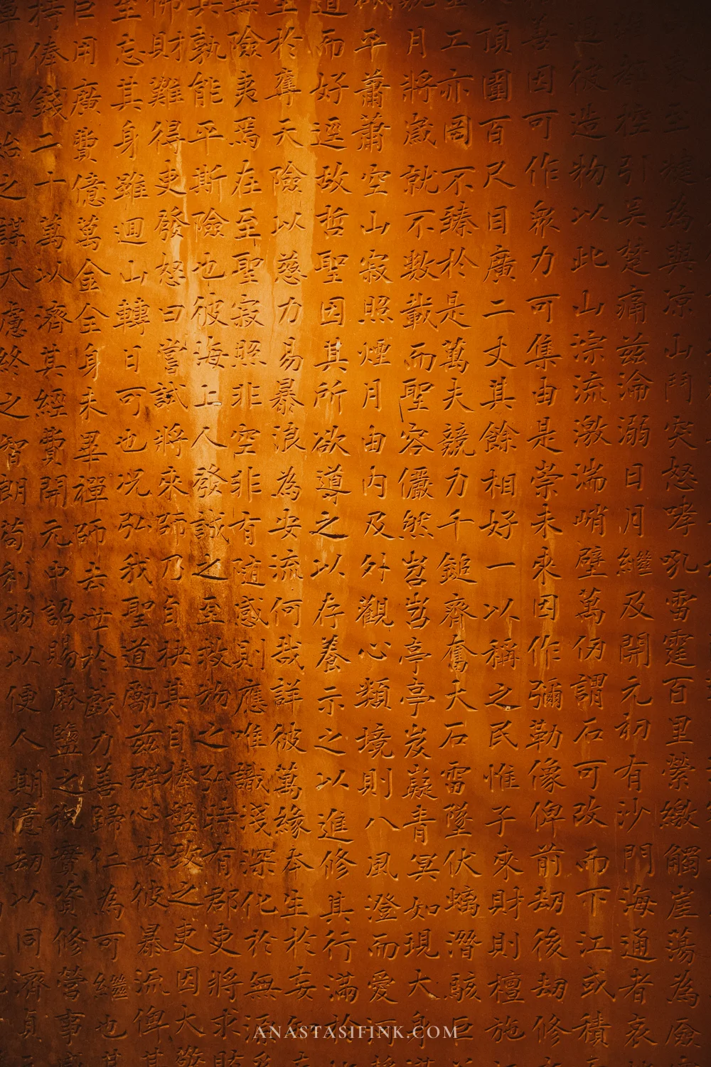 Cliff wall covered in carved sutra characters