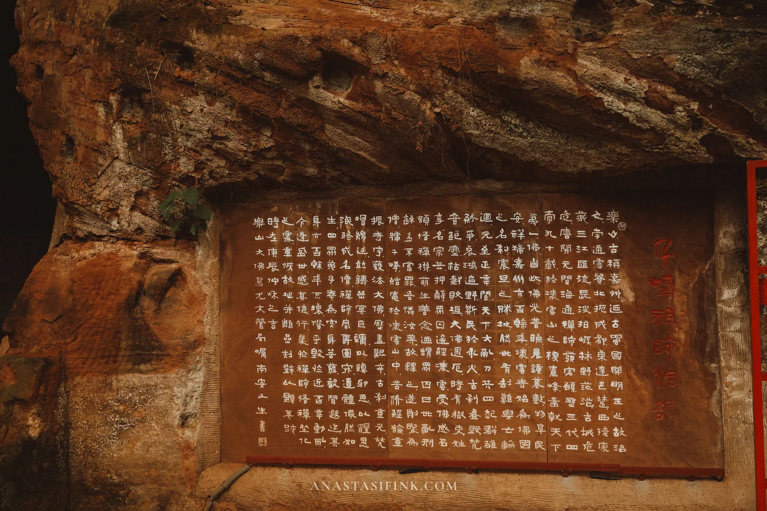 Stone stele with carved text on the cliff