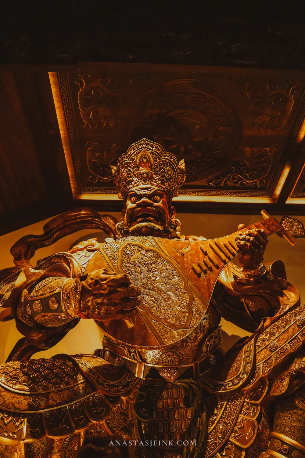 Gilded Heavenly King statue with a pipa lute