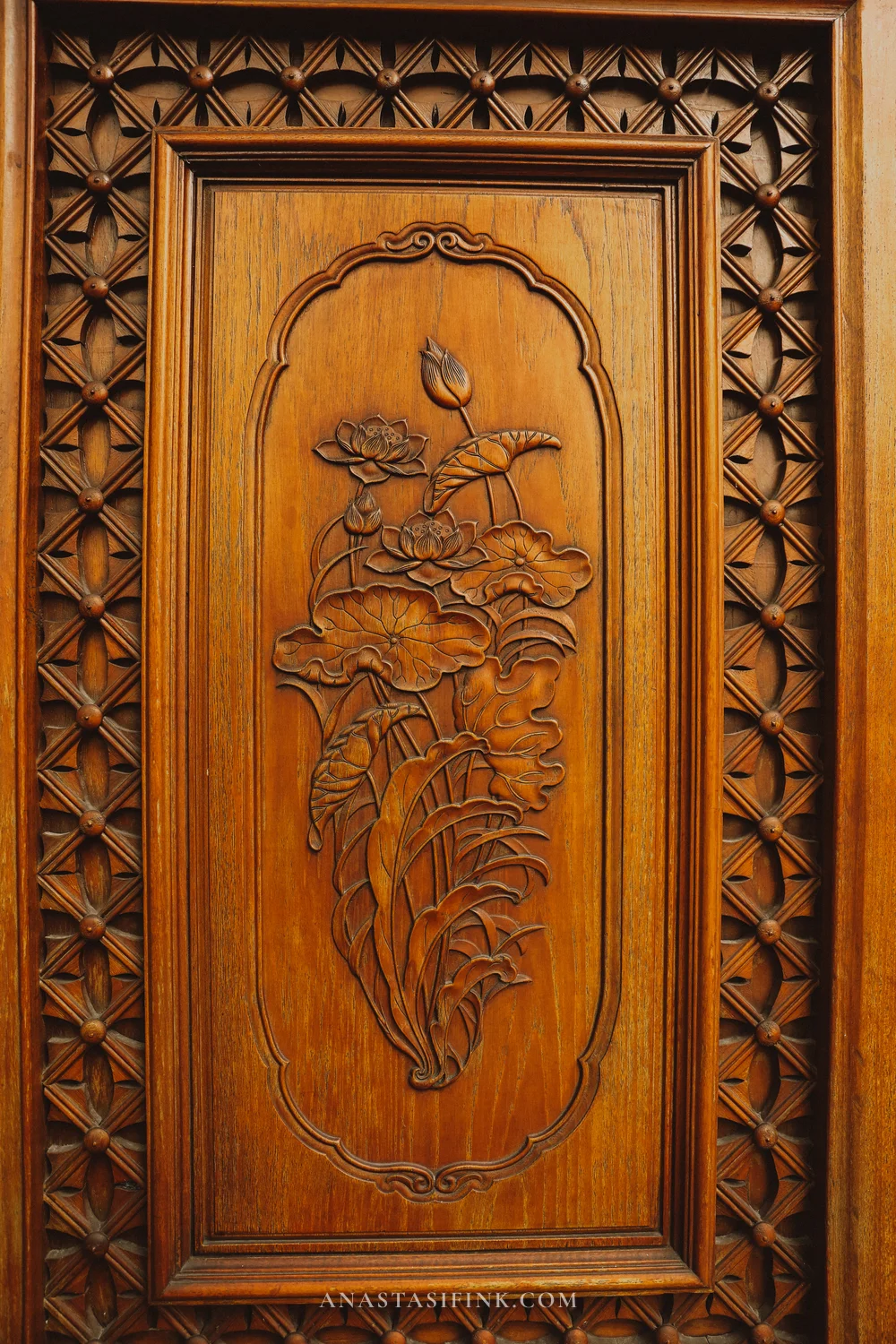Carved wooden door panel with a lotus