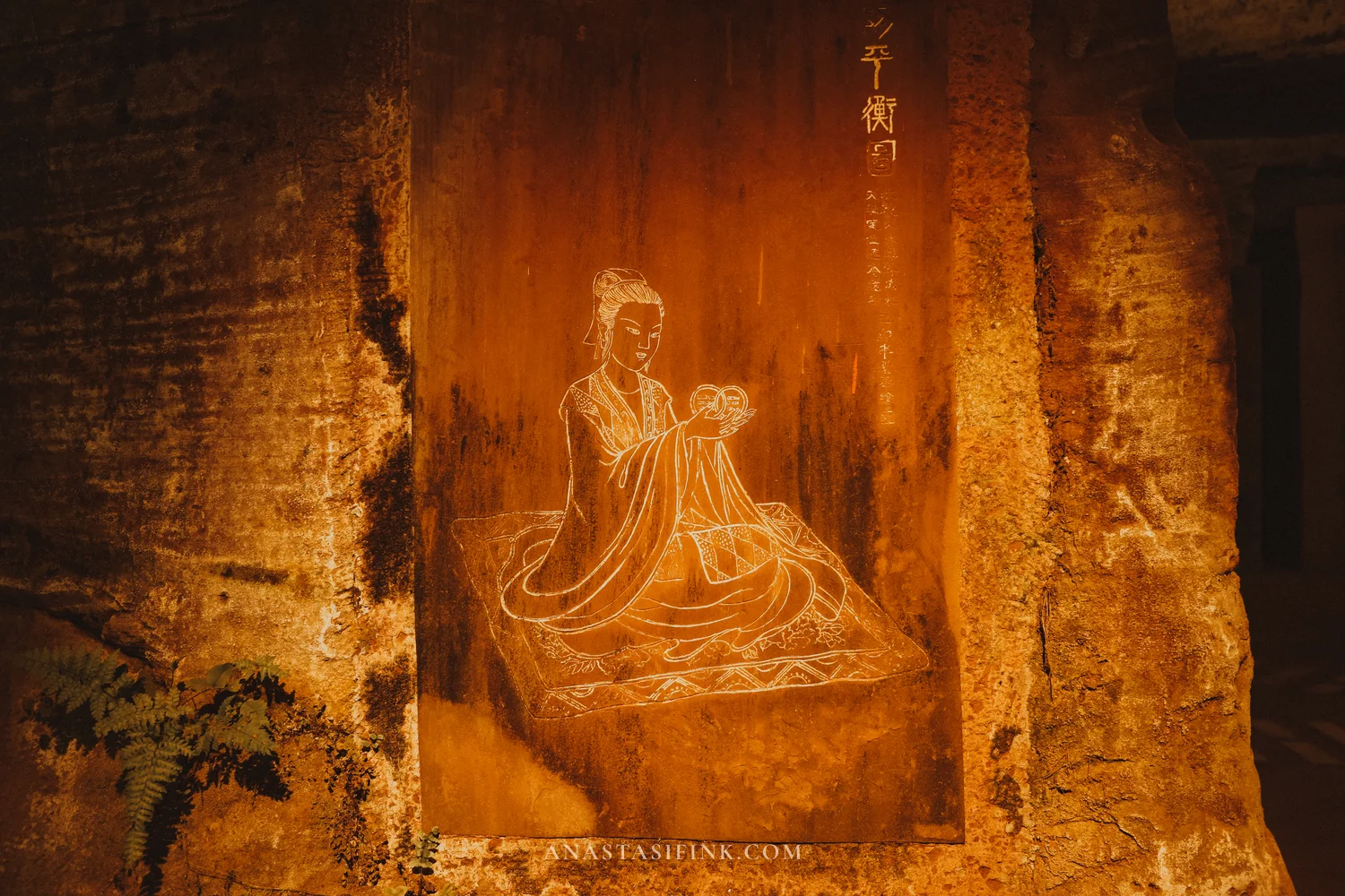 Carving of a seated immortal with a balance symbol