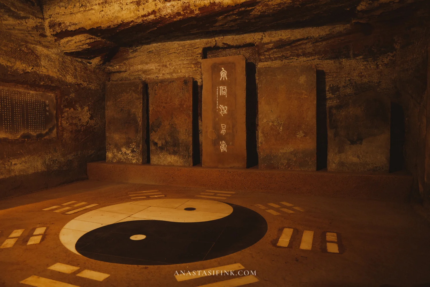 Cave hall with a yin-yang symbol on the floor and trigrams