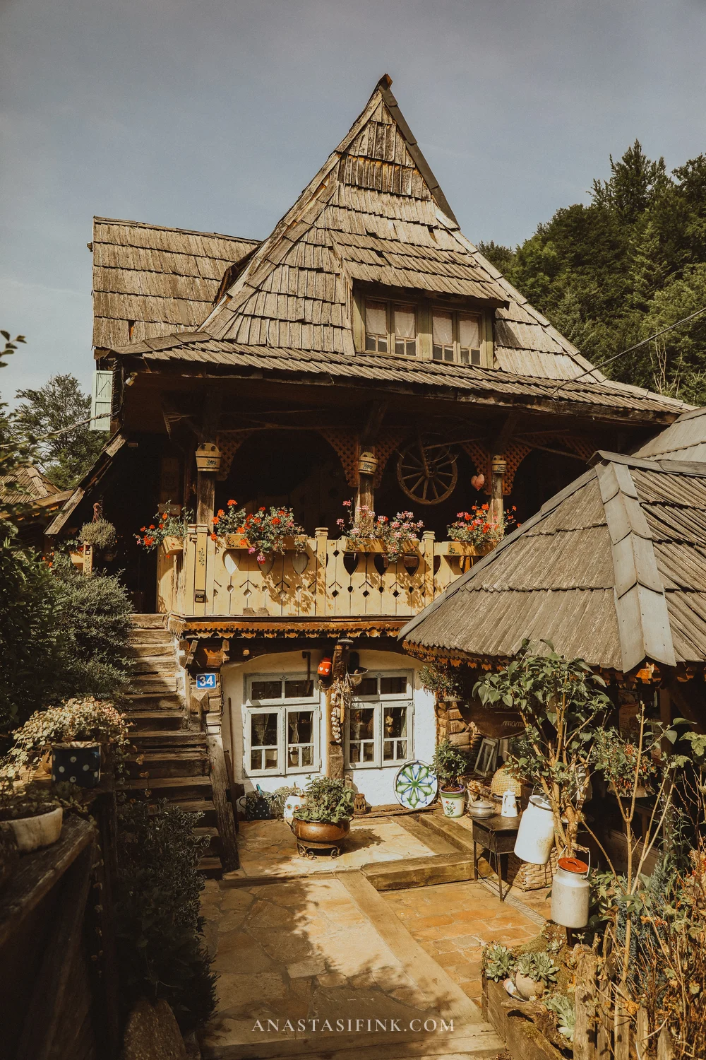 Traditional wooden house with steep shingle roof at Etno Avlija Mackovac village museum, Bosnia