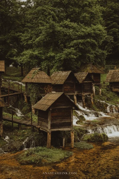 Cluster of small wooden watermills on stilts above cascades at Pliva Lakes near Jajce, Bosnia