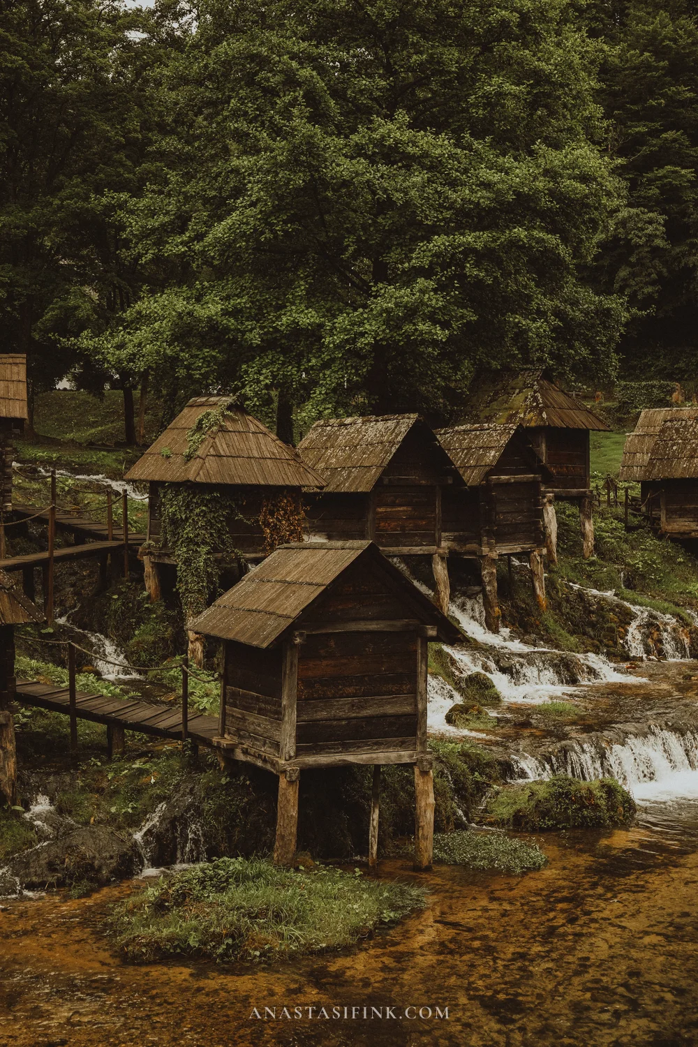 Cluster of small wooden watermills on stilts above cascades at Pliva Lakes near Jajce, Bosnia