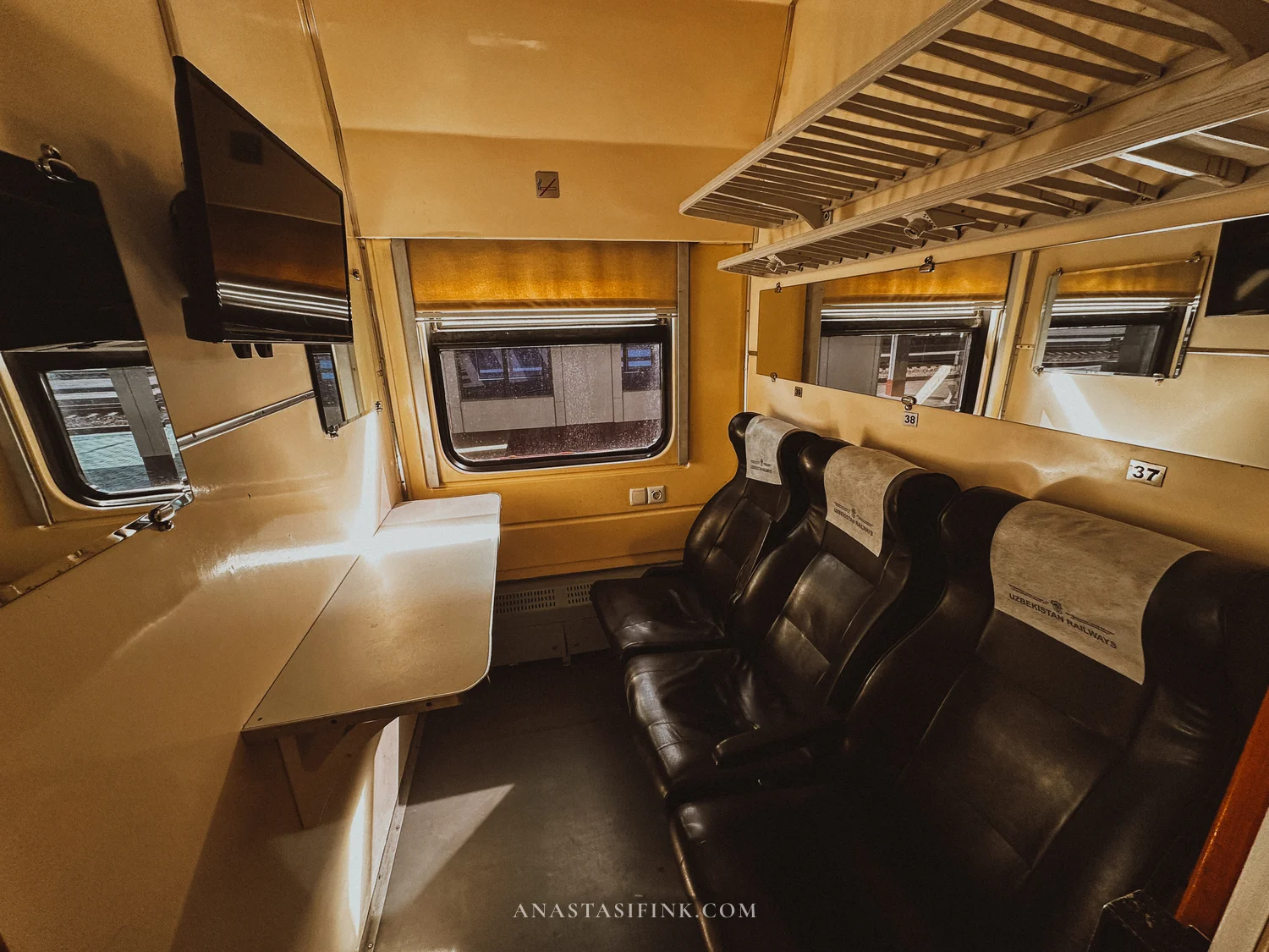 Sharq train compartment: soft seats, a table and a TV